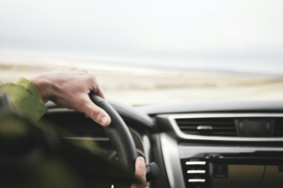 Hands on steering wheel driving down alberta highway