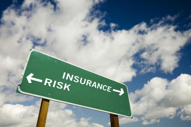 Road sign with "Insurance" pointing one way and "Risk" pointing the other
