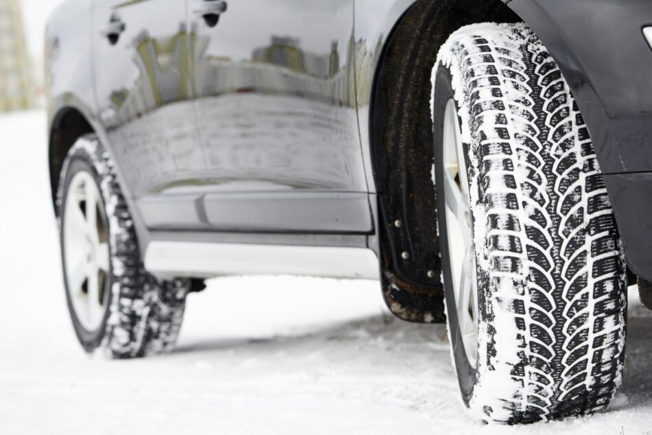 Winter tires on a car that is driving on a snowy road