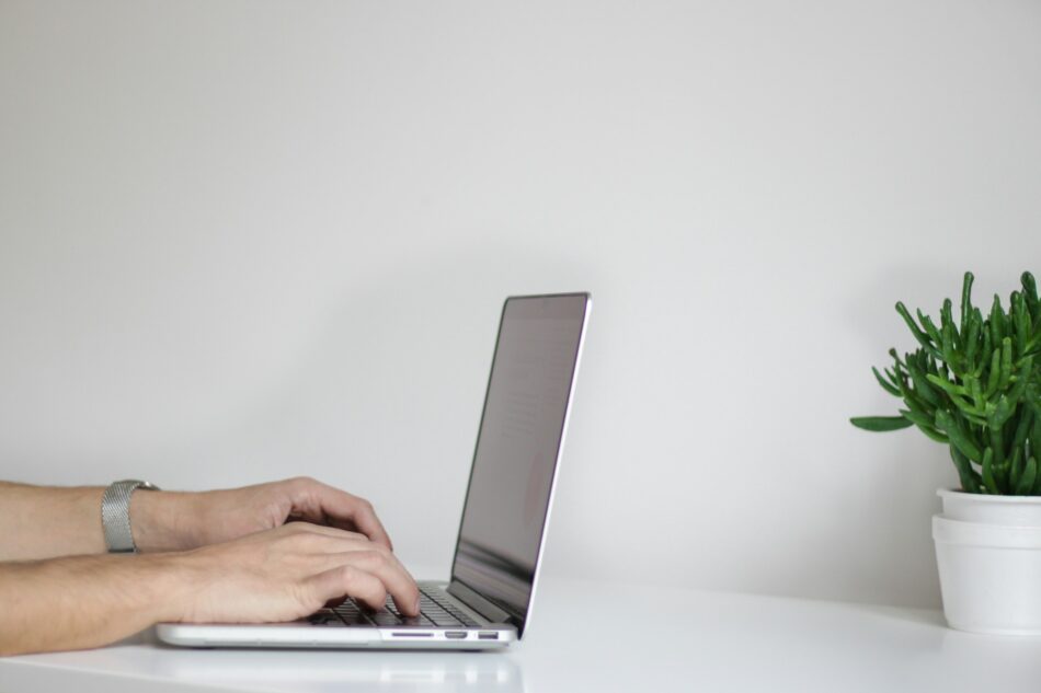 Closeup of hands typing on a laptop