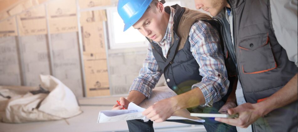 Two construction workers looking at plans on construction site