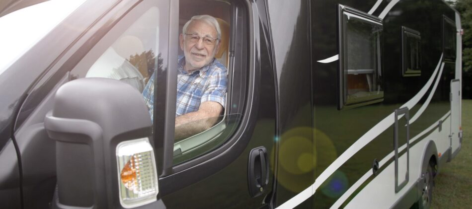 Senior snowbird in RV smiling out the driver side window