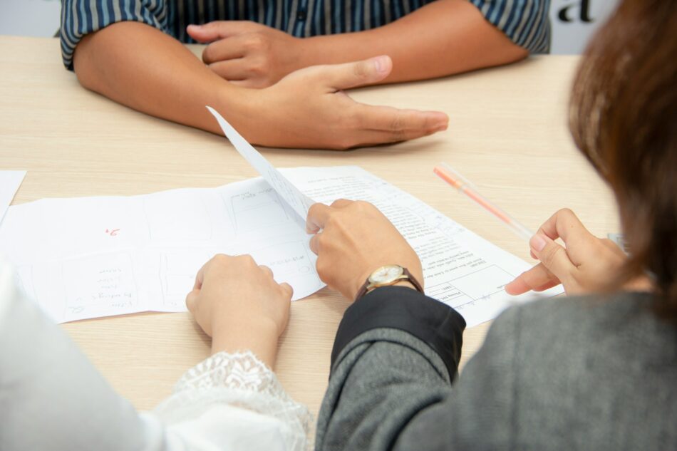 Over-the-shoulder view of people looking at a policy on a desk