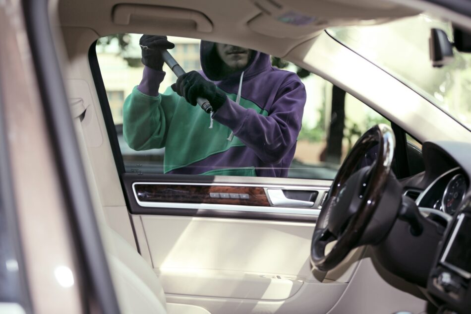 a thief breaking a car window