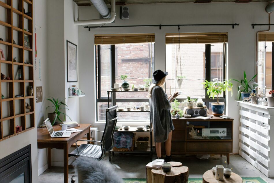 Young woman in her Home-Based Business on phone with laptop sitting open behind her