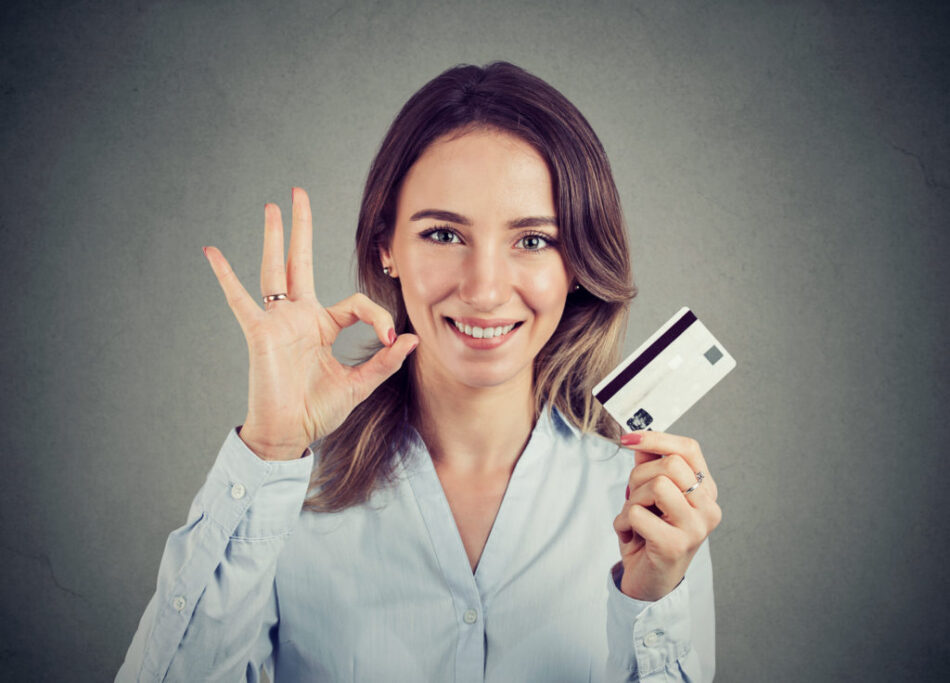happy young business woman with credit card giving ok hand sign gesture