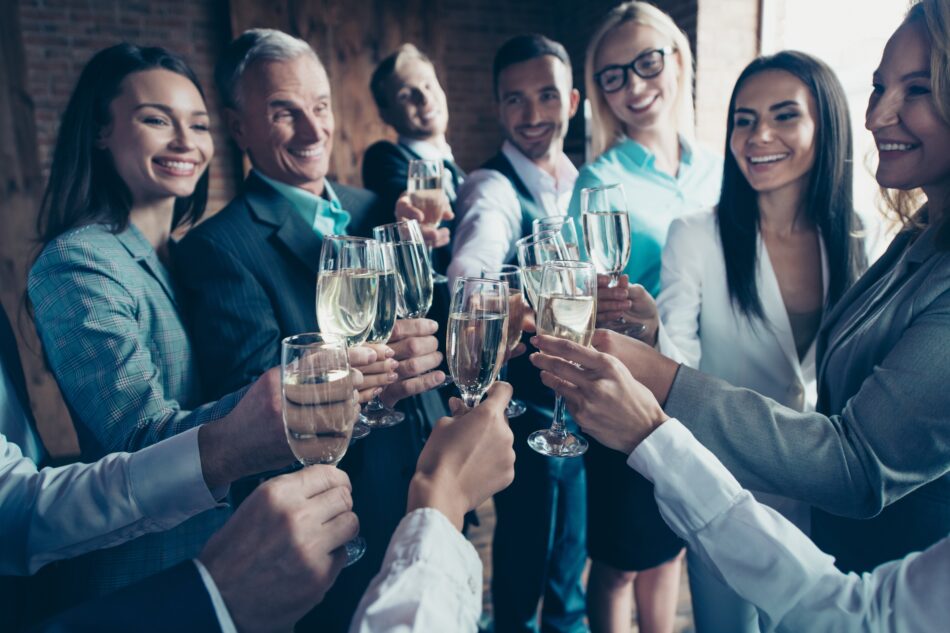 Business people doing a cheers with champagne glasses
