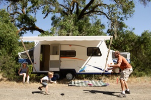 RV with family playing in front on a sunny day