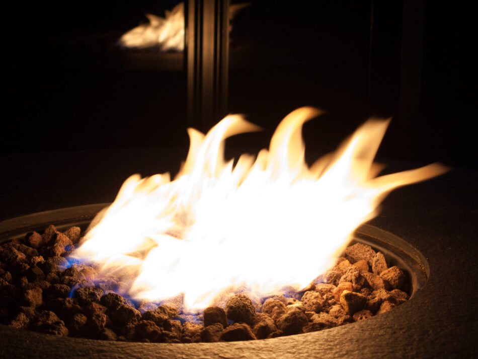 Fire flame in a coal fire pit. Reflection of the fire in the background.