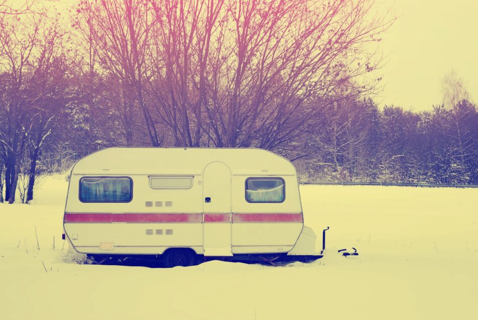 Older trailer sitting in a snowy field