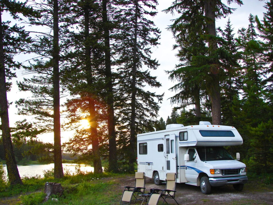 RV parked on lakeside campsite with gravity chairs out front