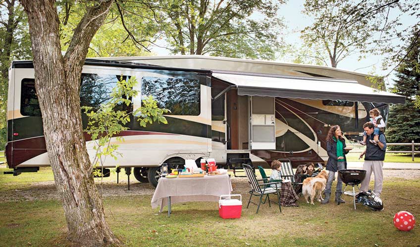 RV parked in lot with family outside enjoying their time