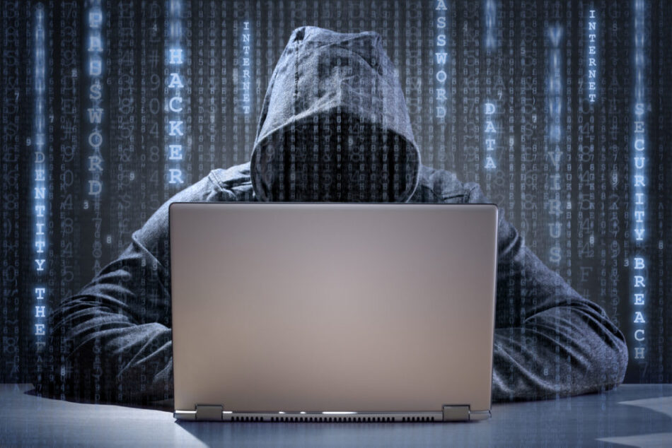Computer hacker stealing data from a laptop concept for network security, identity theft and computer crime