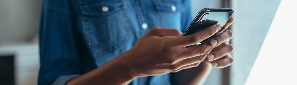 Close up of a Black woman holding a phone.