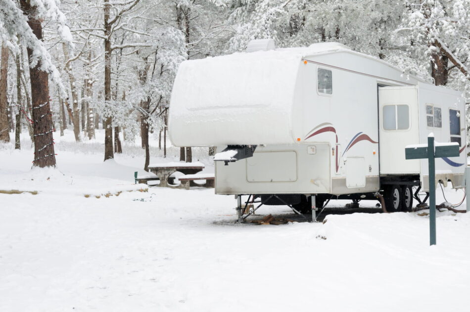 Fifth wheel parked at a campsite in winter.