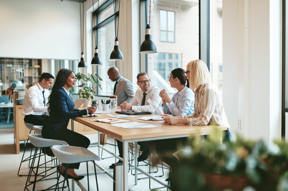 Small group of employees sitting at a table having a casual discussion