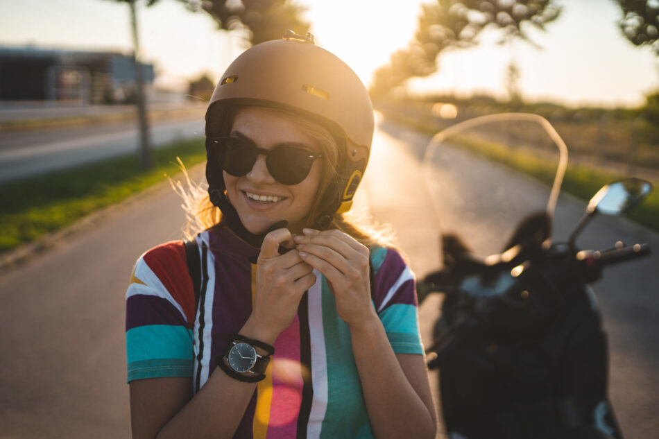 Young girl putting on helmet and getting ready for a motorcycle ride