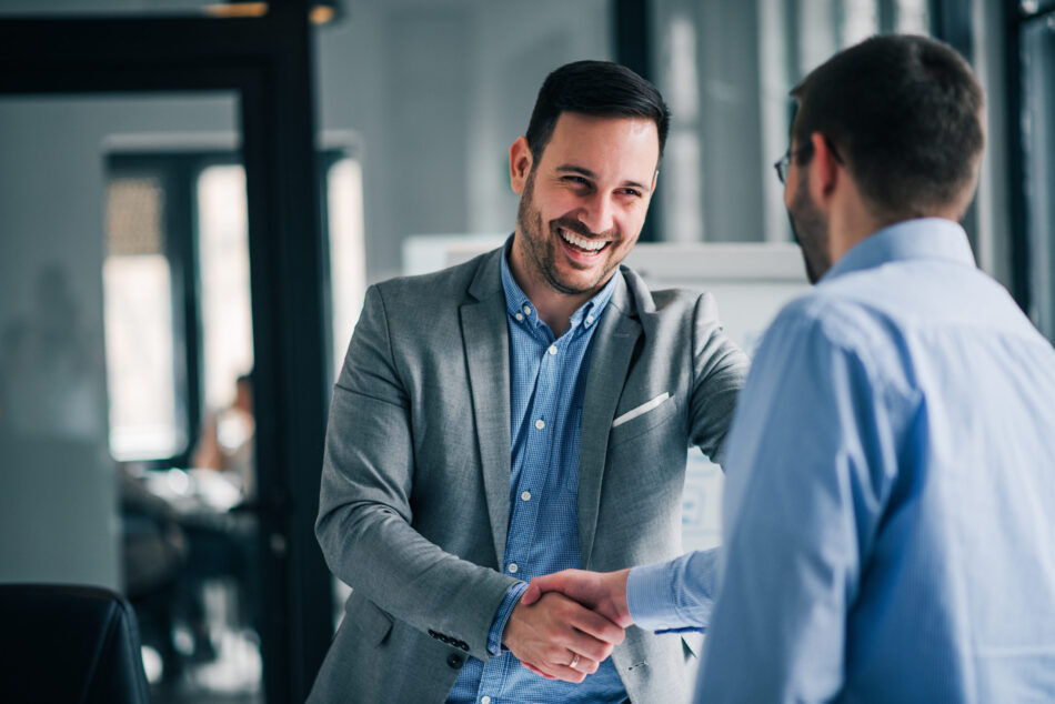 Happy businessman shaking the hand of a client.