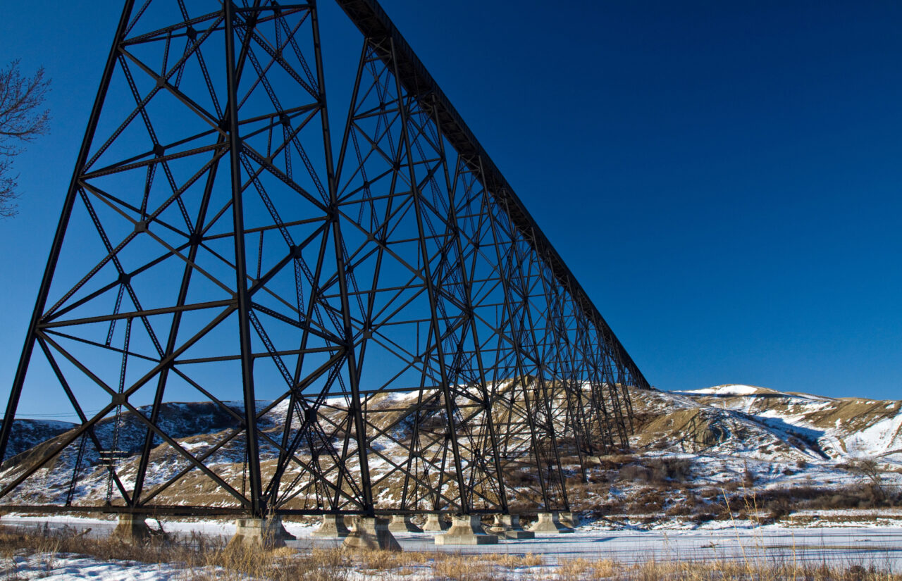 View of a high level rail bridge on a blue sky background seen from below near Lethbridge, Alberta, Canada.