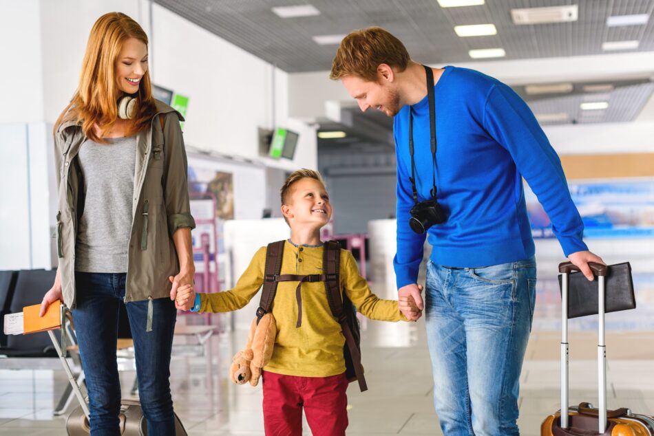 Young family in the airport smiling at each other