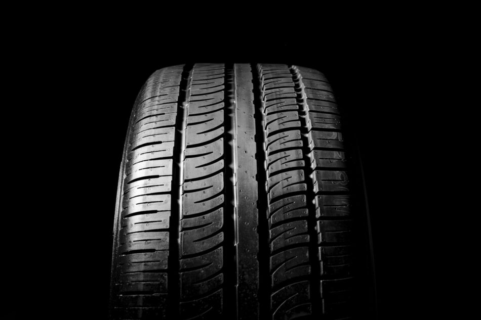Closeup of all-season tire treads on neutral background