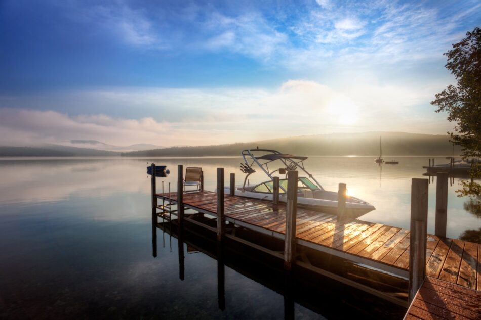 Boat tethered to a wooden dock on a misty lake