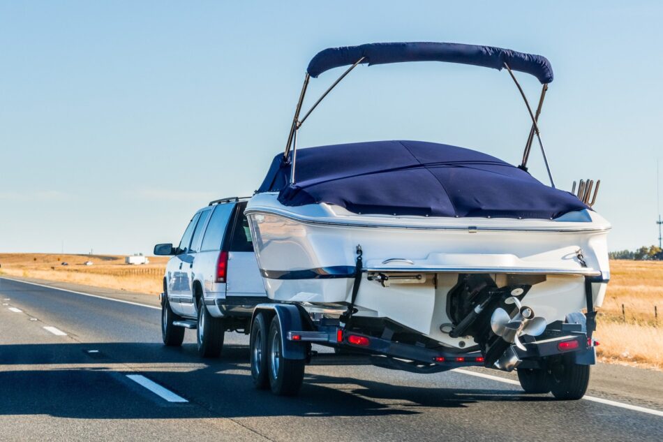 Truck towing a recreational boat on the highway in alberta