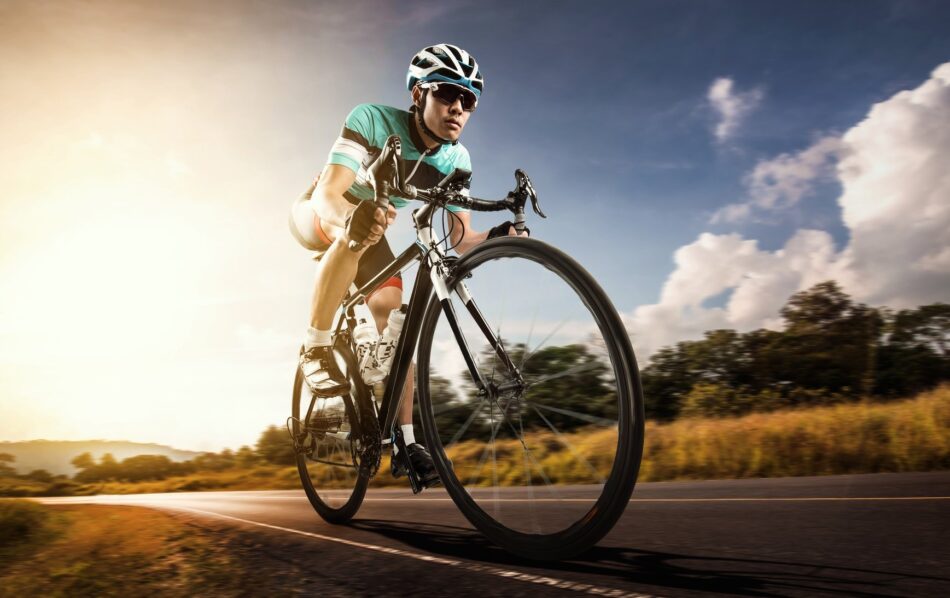 Cyclist riding bicycle down road