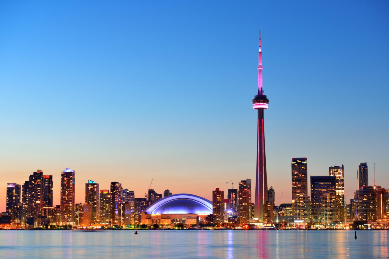 Toronto sunset over lake panorama with urban skyline.