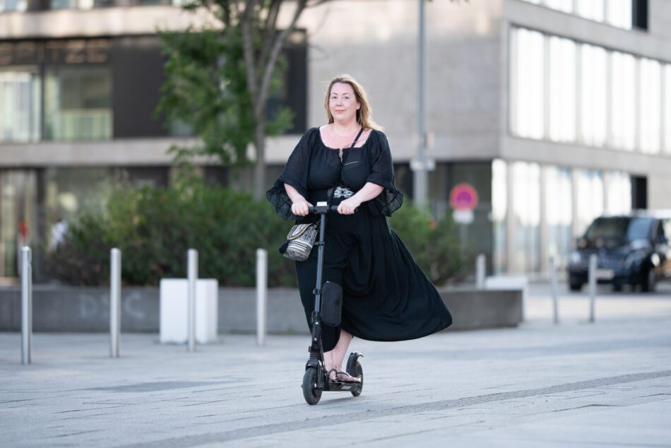 Woman riding electric scooter through the city