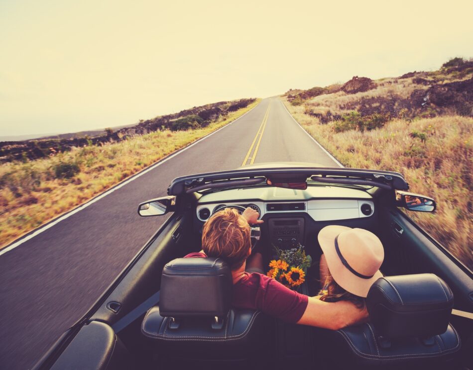 Couple driving in a convertible on a sunny day