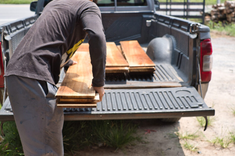 Person loading wood into the bed of their truck