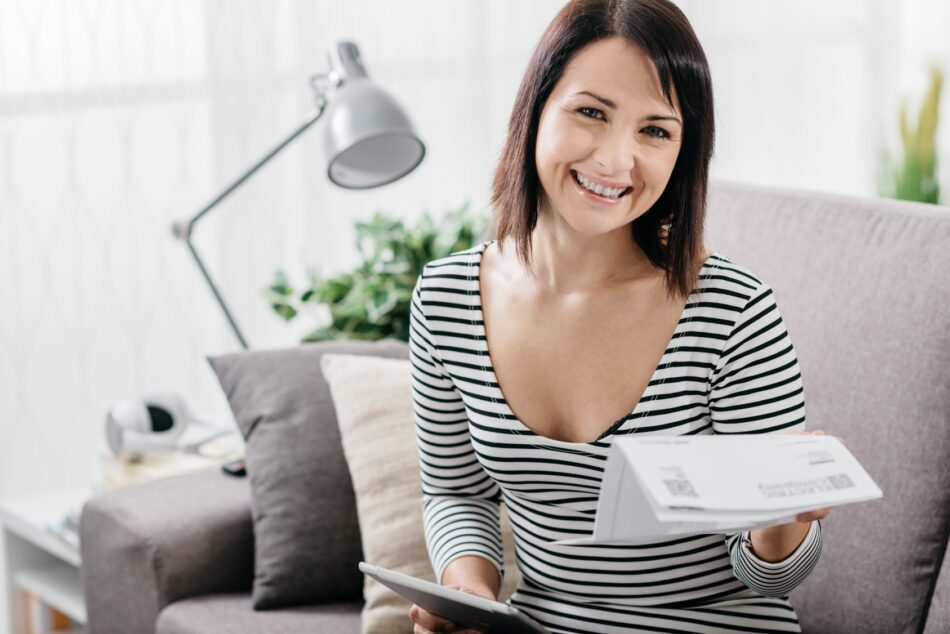 Woman smiling and holding insurance papers