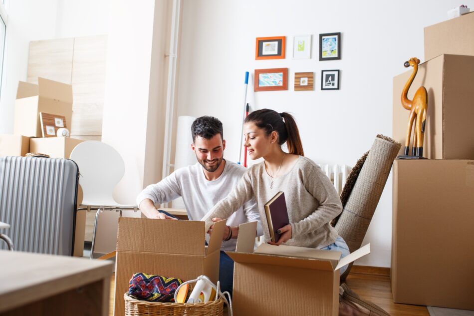 Young couple packing moving boxes
