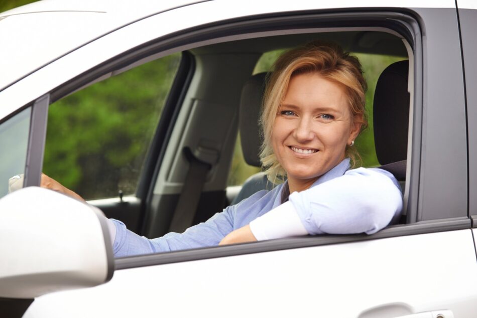 Woman looking out car window and smiling