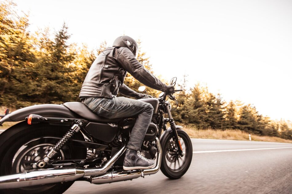 Side view of man on a motorcycle driving tdown the highway