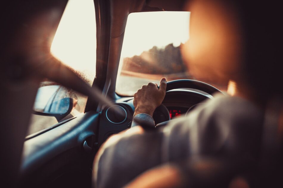 Over the shoulder view of hands on a steering wheel