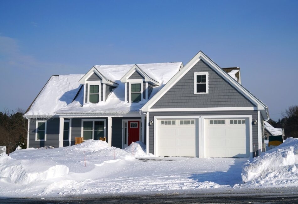 Snowy Alberta two-storey home with clear blue sky behind