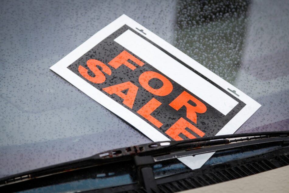 For Sale sign under car windshield
