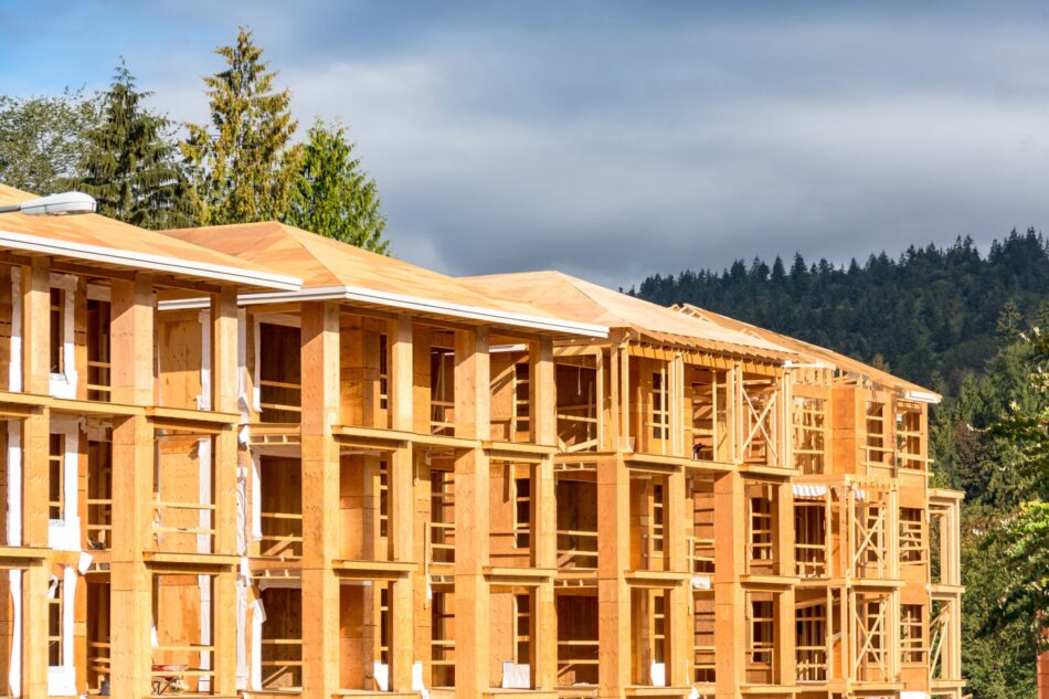 Exterior view of construction on an apartment building that is at the wooden studs level.