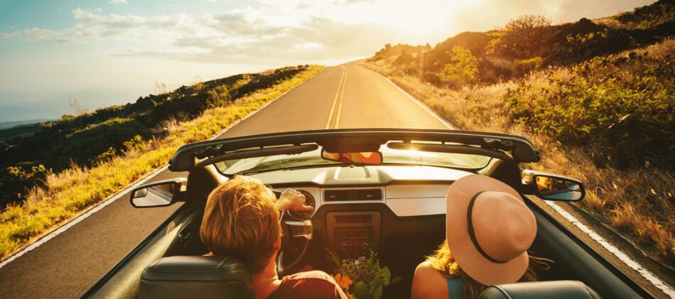 Top view of couple driving in convertible on back road