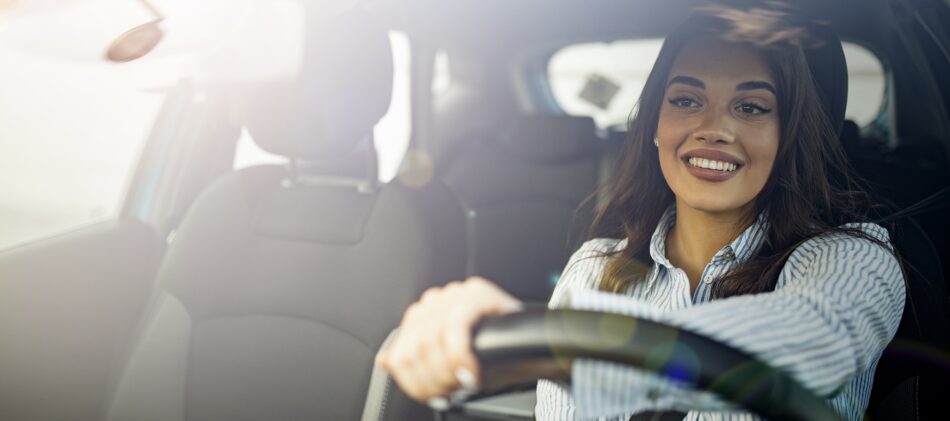 Woman driving car and smiling