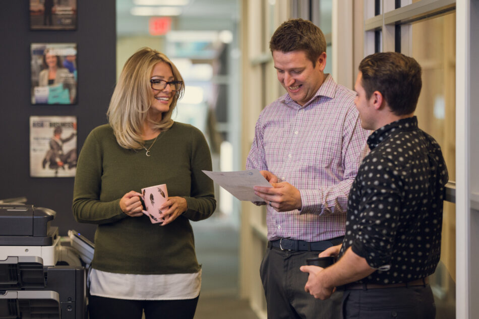 Group of young professionals talking in a hallway