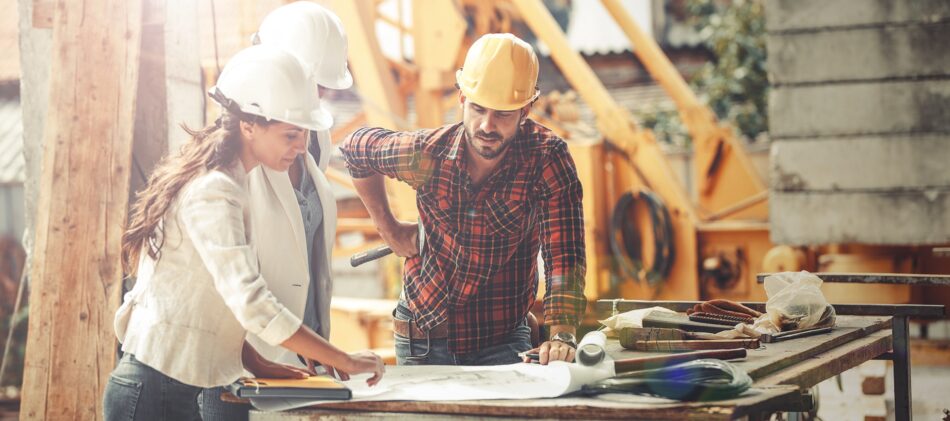 Construction workers and directors looking at plans on construction site