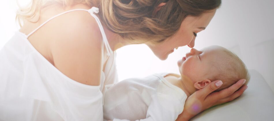 Woman on maternity leave holding baby smiling and rubbing noses