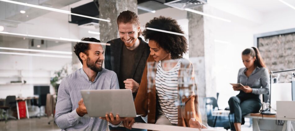 Employees in an office looking something on a computer