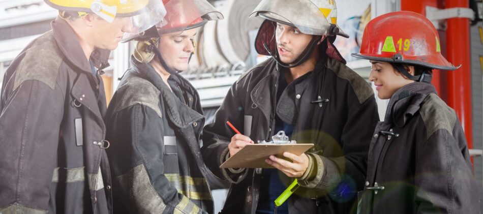 A group of firefighters talking over a clipboard
