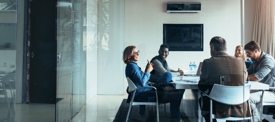 Group of professionals sitting around a table having a discussion in a boardroom