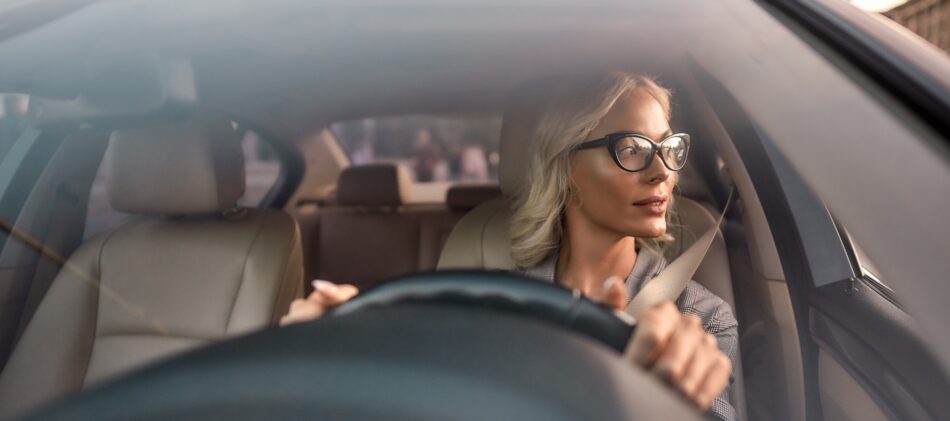Woman in drivers seat of car looking out the window