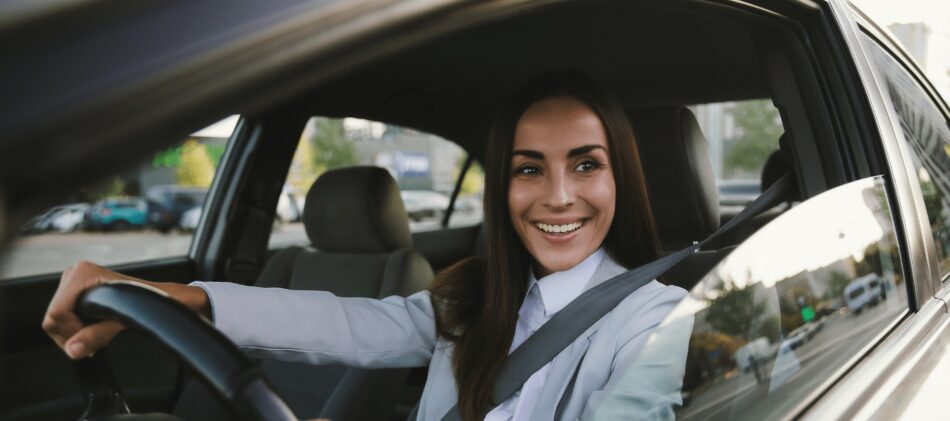 Woman driving car and smiling